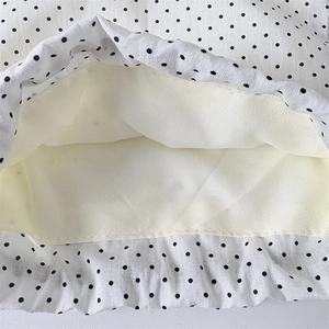Macro detail of polka dot drawstring bag showing premium fabric texture and neat stitching