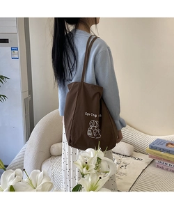 Détail d'un grand sac cabas marron en toile avec motif Spring et fines bandoulières