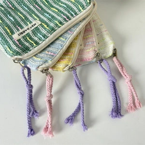 Detailansicht bunter Tweed-Minibörsen mit typischen Fransenquasten und Reißverschluss
