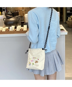 Detailed embroidery on off-white canvas crossbody bag with colorful dog and floral patterns