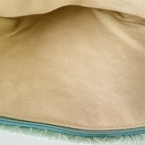 Detailed close-up of light green pleated fabric with secure zipper and beige lining