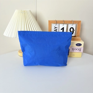 Détail de la trousse de maquillage en nylon bleu Klein avec fermeture éclair fluide