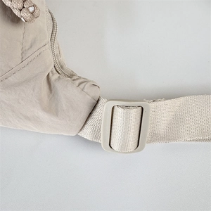 Detail of nylon dumpling bag showing reinforced stitching and adjustable plastic buckle