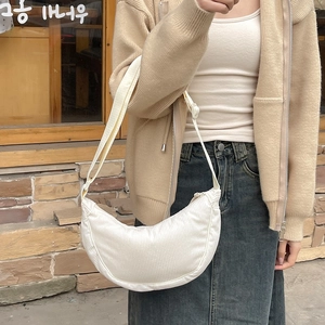 Detailed close-up of a white corduroy crescent bag with adjustable wide strap for daily use