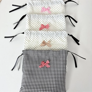 Detailed view of polka dot and gingham fabric jewelry pouches with colorful bow accents