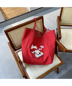 Detail of red canvas tote bag with Cherry Cake embroidery and red checkered lining