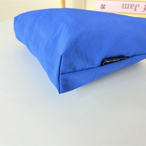 Gros plan d'une trousse de maquillage en nylon bleu roi montrant la texture et les coutures