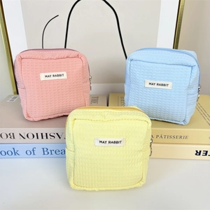 Detailansicht quadratischer Waffelstruktur-Taschen in Pastellrosa, Blau und Gelb
