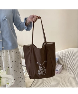 Détail du sac cabas en toile marron avec texte spring outing et illustration d'ours