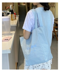 Close-up of a large blue tote bag featuring 'Onfave' text and blue checkered strap detail