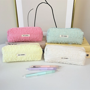 Detail of colorful macaron pleated fabric pencil cases with metal zippers and fabric labels