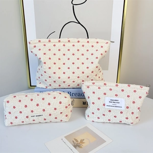Three-piece floral seersucker cosmetic bag set with zipper and brand label