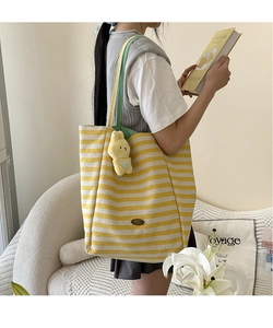 Détail du sac cabas en toile à rayures jaunes avec pendentif lapin et étiquette en cuir