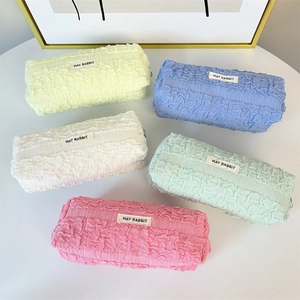 Close-up of pleated fabric stationery bags in five pastel colors with May Rabbit label
