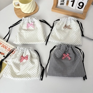 Detailed view of polka dot and plaid drawstring bags with bow accents for jewelry storage