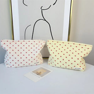 Detail of floral bubble fabric makeup bags in white and yellow with MAY RABBIT tag