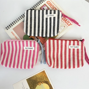 Striped canvas coin purses in black, pink, and red with zippers and wrist straps
