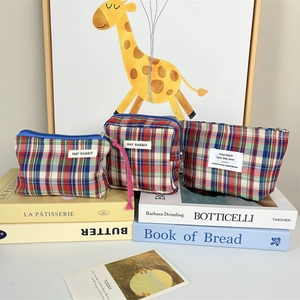Detailed set of three plaid makeup bags with blue zippers and blue-white grid texture