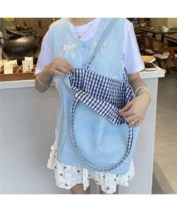 Detail of the blue canvas tote bag with letter print and blue checkered lining