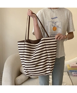 Détail du grand sac cabas en toile rayée montrant la capacité et les bandoulières