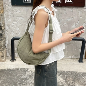 Close-up of olive green corduroy crescent bag texture and adjustable strap detail