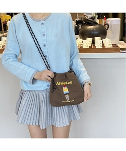 Brown drawstring bucket bag with ice cream embroidery worn by a model in casual style