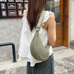 Detailed view of army green corduroy half-moon crossbody bag on female model