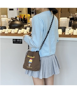 Detail of embroidered ice cream cone and ISALUBU text on dark brown canvas bucket bag
