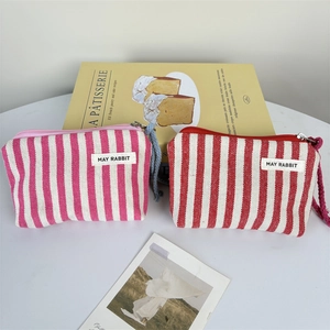 Detailed macro view of pink and red striped canvas coin purses with woven zipper pulls