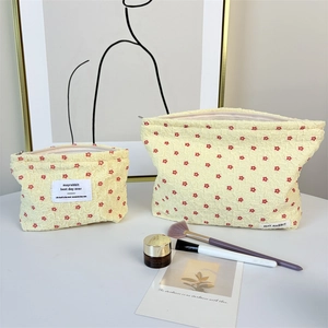 Detail of yellow floral seersucker cosmetic bags in two sizes for makeup storage