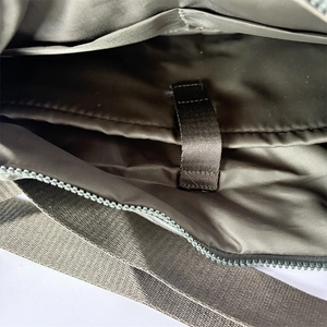 Vue intérieure montrant le compartiment PC spacieux et la doublure en nylon du sac à bandoulière