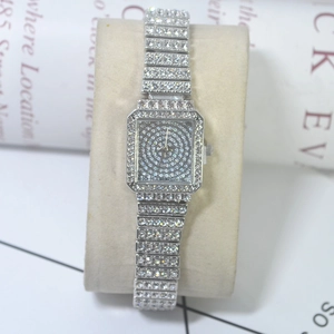 Close-up of silver rectangular quartz watch with full rhinestone inlay on display pillow