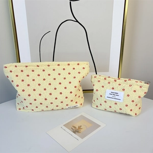 Detailed view of floral makeup bag set with unique pleated texture and red flower pattern