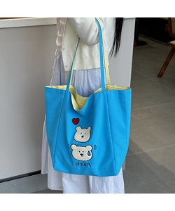 Close-up of blue canvas tote bag with cute bear embroidery and yellow checkered lining