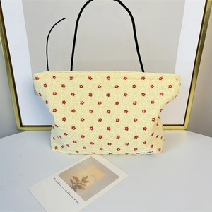 Detail of yellow floral pleated pouch with MAY RABBIT label and black strap handles