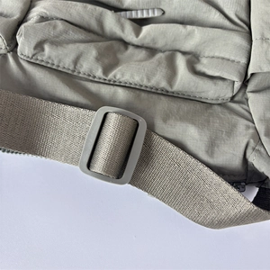 Détail de la boucle de sangle sur un sac bandoulière en nylon gris-vert étanche