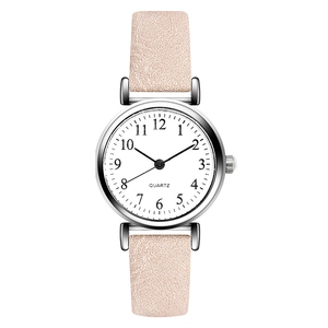 Close-up of white dial with Arabic numerals on a pink leather strap quartz watch