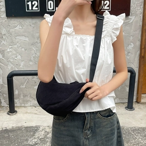 Black corduroy crescent crossbody bag shown on a model for a casual and versatile style