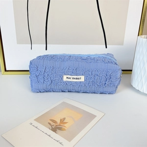 Detailed view of sky blue pleated fabric pencil case with May Rabbit woven label
