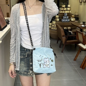 Light blue nylon drawstring crossbody bag with cute cartoon embroidery and braided strap