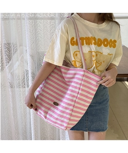Détail du sac cabas en toile à rayures roses et beige avec écusson en cuir et grande taille