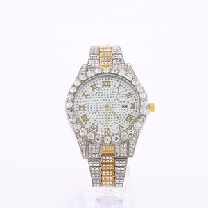 Close-up of luxury iced-out watch with silver and gold steel band and calendar window