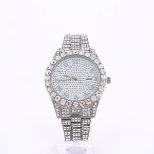 Detail view of silver luxury diamond watch with Roman numerals on a crystal dial