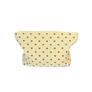 Floral makeup bag in cream yellow bubble fabric with red flower embroidery for storage