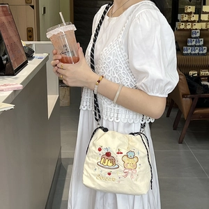 Detailed embroidery of chef bear and Sweet text on beige drawstring nylon crossbody bag