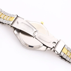 Detail of two-tone crystal-encrusted metal strap with secure butterfly clasp closure