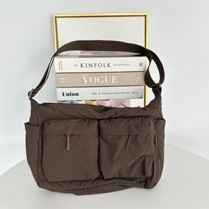 Détail d'un sac bandoulière marron en nylon avec double poches zippées et sangle large