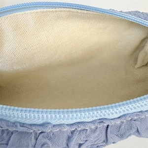 Detailed macro view of light blue pleated fabric pouch with durable beige canvas lining