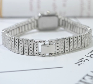 Detailed macro view of silver steel watch band with dot texture and fold-over clasp