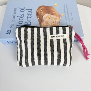 Detail of striped canvas coin purse with pink zipper pull and MAY RABBIT label